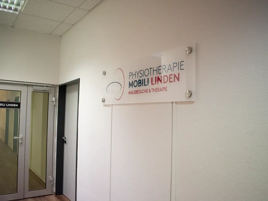 Eingangsbereich der Physiotherapie Mobili Linden mit Tür und Praxisschild für Hausbesuche und Therapie.