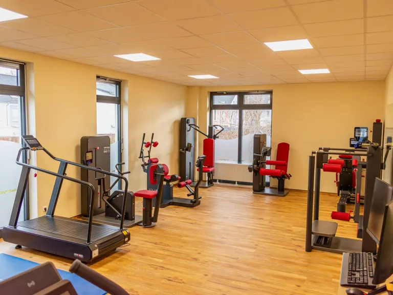 Heller Trainingsraum mit modernen Geräten für medizinische Trainingstherapie in der Physiotherapie.